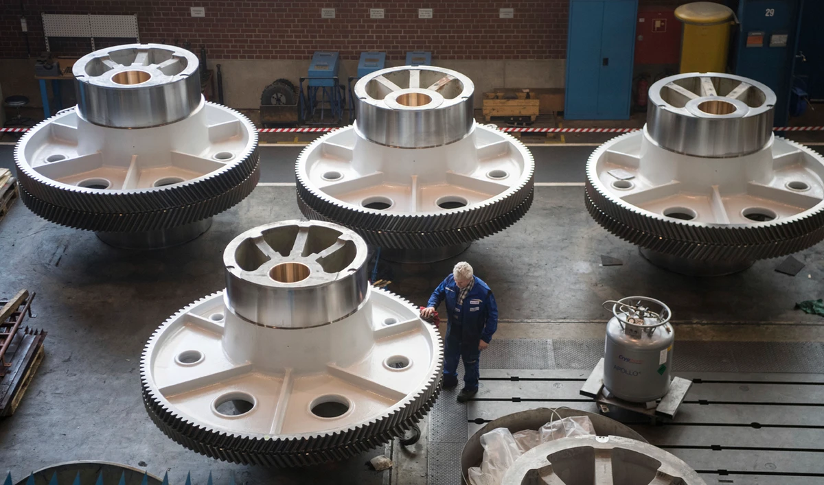 A worker cleans big machine parts in Goeppingen, Germany. (DPA via AP)