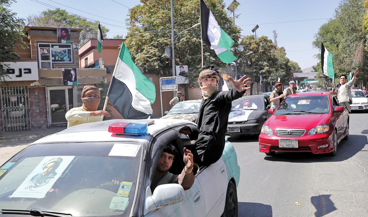 Afghans in cars decorated with flags and portraits of late Commander Ahmad Shah Massoud mark the 18th anniversary of his death, in Kabul on Monday. (AP)