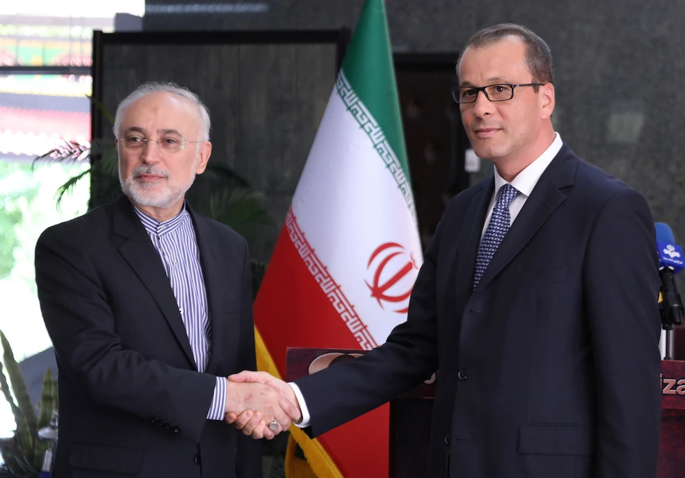 The acting head of the IAEA, Cornel Feruta, shakes hands with Ali Akbar Salehi, director of Iran's nuclear energy agency in Tehran, on Sunday. (Reuters)