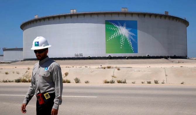 An Aramco employee walks near an oil tank at Saudi Aramco's Ras Tanura oil refinery and oil terminal in Saudi Arabia. (Reuters)
