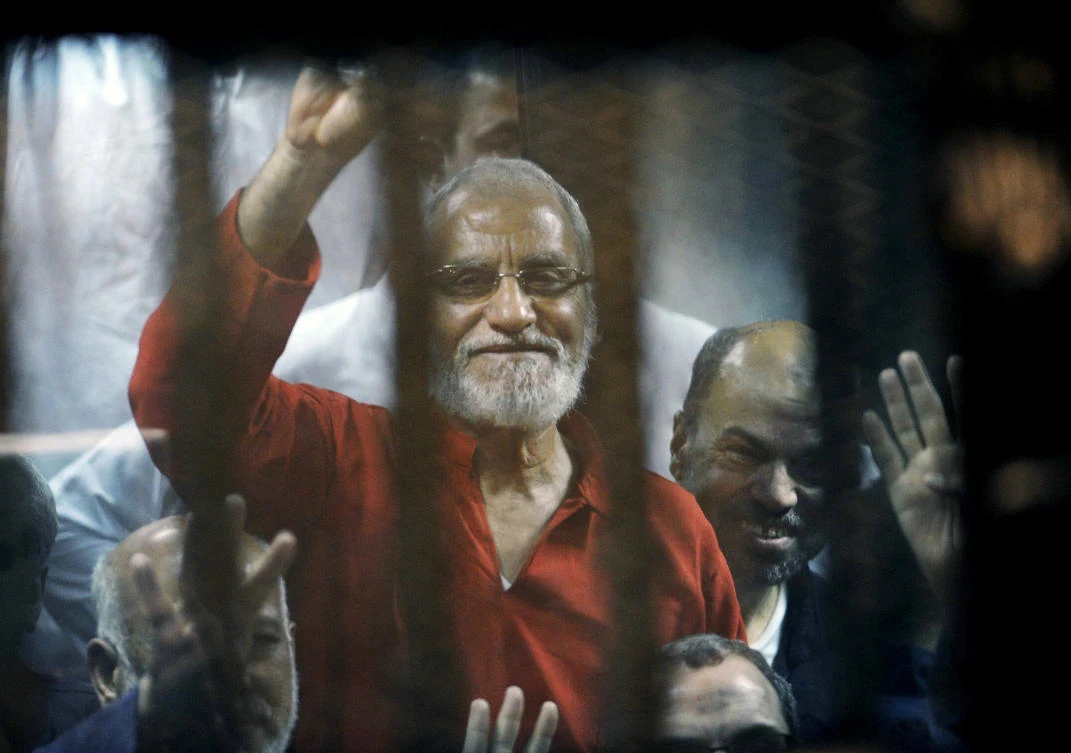 In this file photo dated Saturday, May 16, 2015, Muslim Brotherhood spiritual leader, Mohammed Badie waves from a defendants cage in a makeshift courtroom at the national police academy, in eastern Cairo, Egypt. (AP)