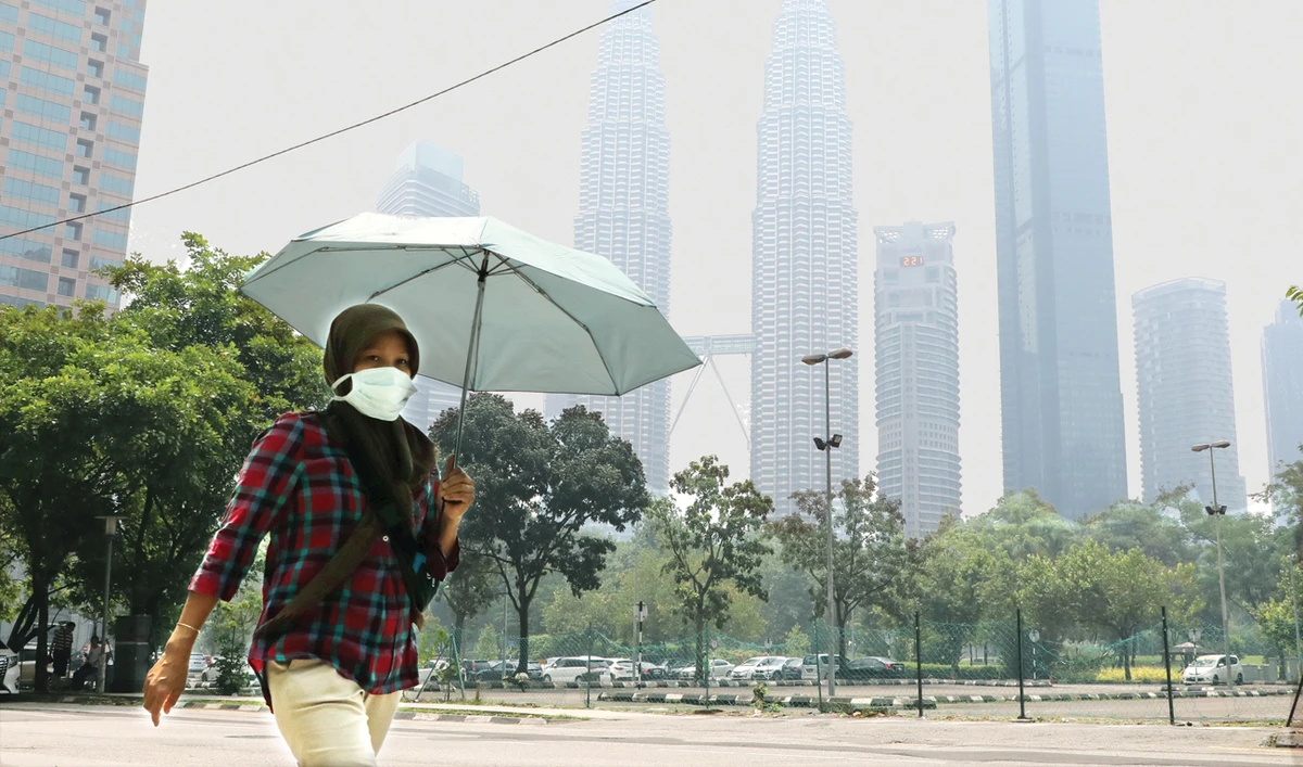 A woman wears a mask as the Petronas Twin Towers are shrouded in haze in Kuala Lumpur on Wednesday. (Reuters)
