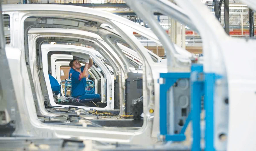An employee works on the automobile assembly line of electric city cars. (Reuters)