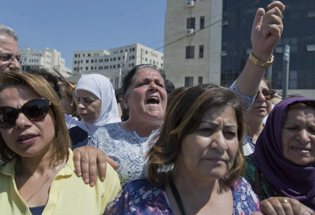 A Palestinian woman chants slogans during a rally in front of the Prime Minister's office, in the West Bank city of Ramallah. (File/AP)