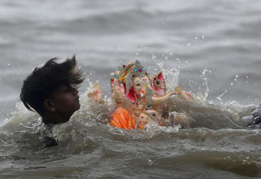 A devotee carries an idol of elephant-headed Hindu god Ganesha for immersing in the waters on the Ganesh Chaturthi festival in Mumbai, India. (AP)