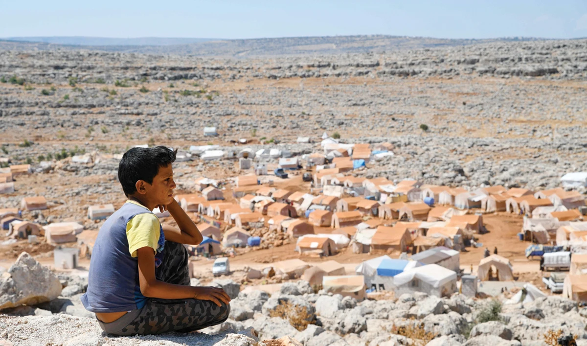 A Syrian boy, displaced from the town of Khan Sheikhoun, gazes at the makeshift camp where he currently lives in Idlib, near the Turkish border. (AFP)