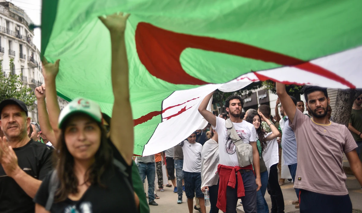 Algerian protesters wave their national flag, during a demonstration against the ruling class in the capital Algiers. (AFP)