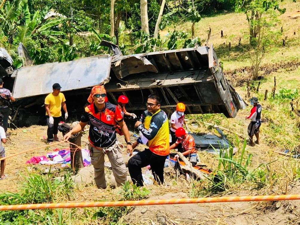 Rescue workers stand next to a flatbed truck that fell into a ravine in T’Boli town of South Cotabato on Tuesday, September 17, 2019. (Rolly Aquino/Michael Acas/AFP)