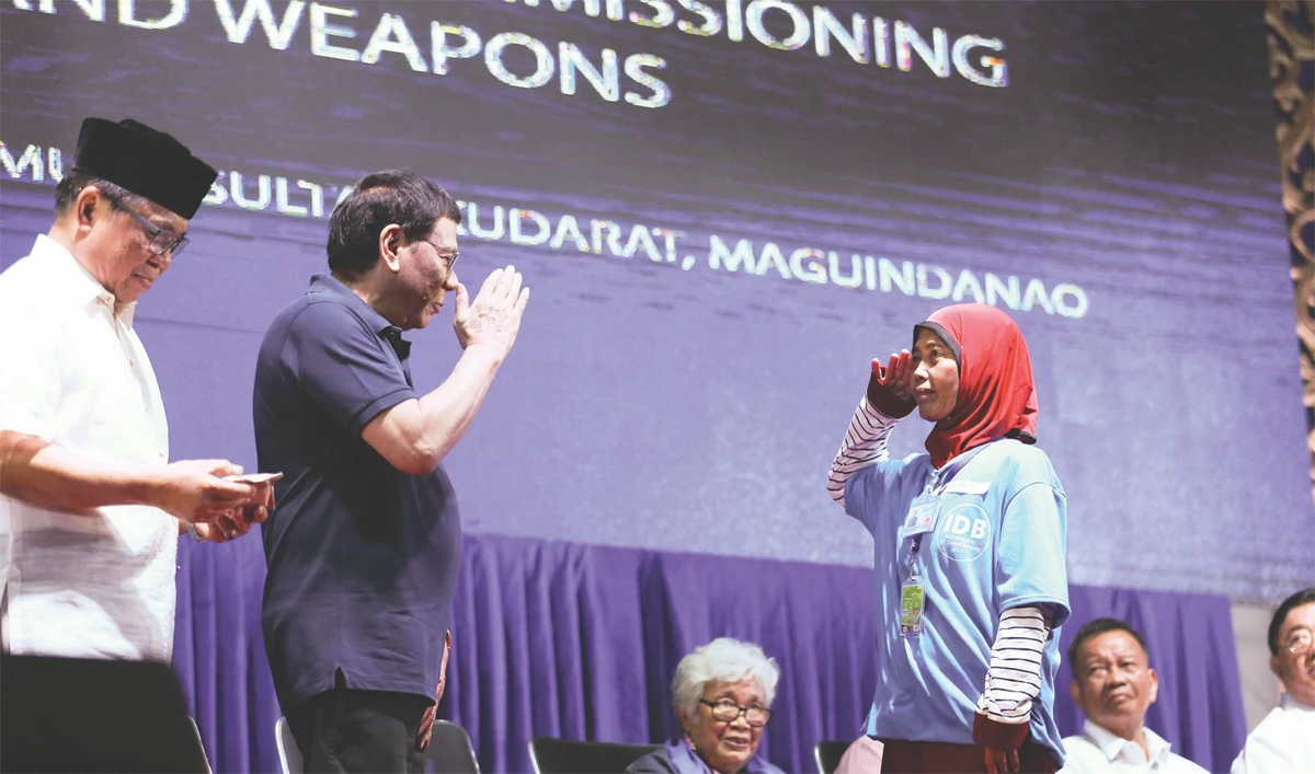 Duterte salutes and greets former members of the MILF at their passing out ceremony. Malacañang photo