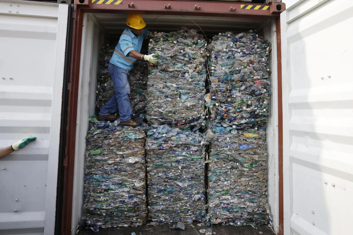 A worker stands inside a container full of plastic waste at Tanjung Priok port in Jakarta, Indonesia Wednesday, Sept. 18, 2019. (AP)