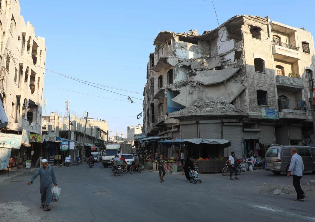 A file photo shows people walk near heavily damaged buildings in the rebel-held city of Idlib in northwestern Syria on September 16, 2019. (AFP)