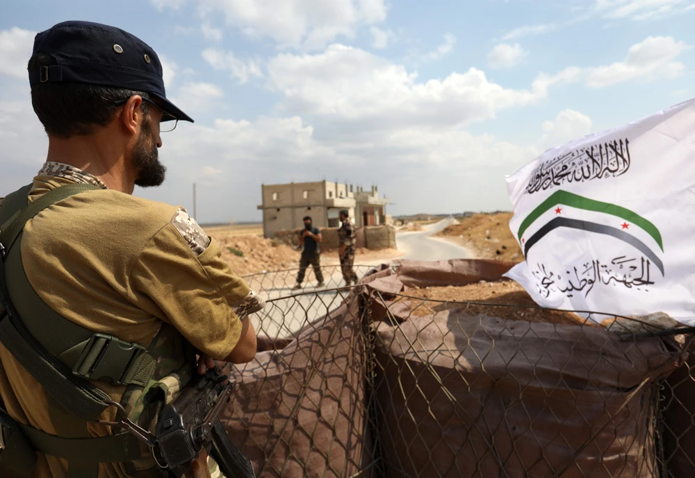 Syrian fighters from the Turkish-backed NLF hold a frontline position facing regime-controlled areas in the Abu Zuhur region of the northern Idlib province. (AFP)