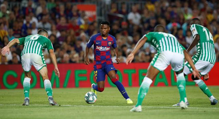 Barcelona’s Anssumane Fati faces a phalanx of Real Betis defenders at the Camp Nou. (Reuters)
