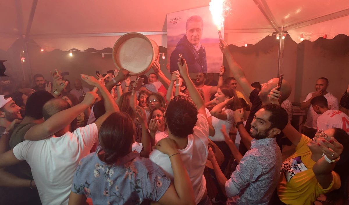 Supporters of Tunisia's jailed presidential candidate Nabil Karoui (not pictued) celebrate in front of his headquarters in the Tunisian capital Tunis. (File/AFP)