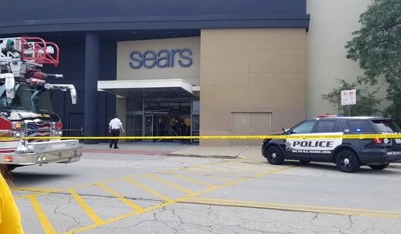 Security personnel watch over the damaged entrance of Woodfield Mall in Schaumburg, Illinois in this picture obtained from social media. (Reuters)