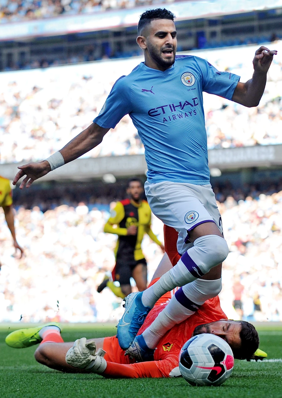 Watford’s goalkeeper Ben Foster, down, fouls Manchester City’s Riyad Mahrez during Saturday’s match. (AP)