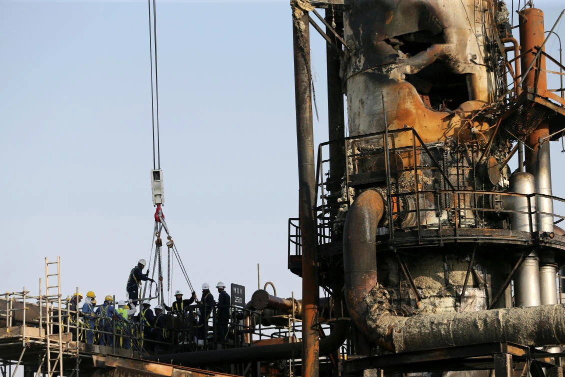 Workers are seen at the damaged site of Saudi Aramco oil facility in Abqaiq, Saudi Arabia, on Thursday. (Reuters)