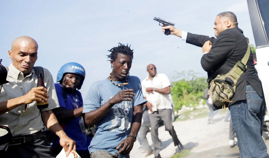 People run as Haiti's Senator Jean Marie Ralph Fethiere (PHTK) fires a gun in the air, injuring Chery Dieu-Nalio, a photographer for Associated Press, while facing opposition supporters in the parking lot of the Haitian Parliament and Senate, as the government attempted to confirm the appointment of nominated Prime Minister Fritz William Michel, in Port-au-Prince, Haiti September 23, 2019. (REUTERS)
