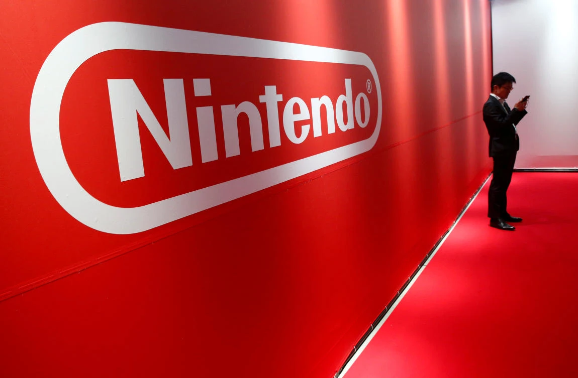 A man stands in front of Nintendo's logo at the presentation ceremony of its new game console Switch in Tokyo. (Reuters)