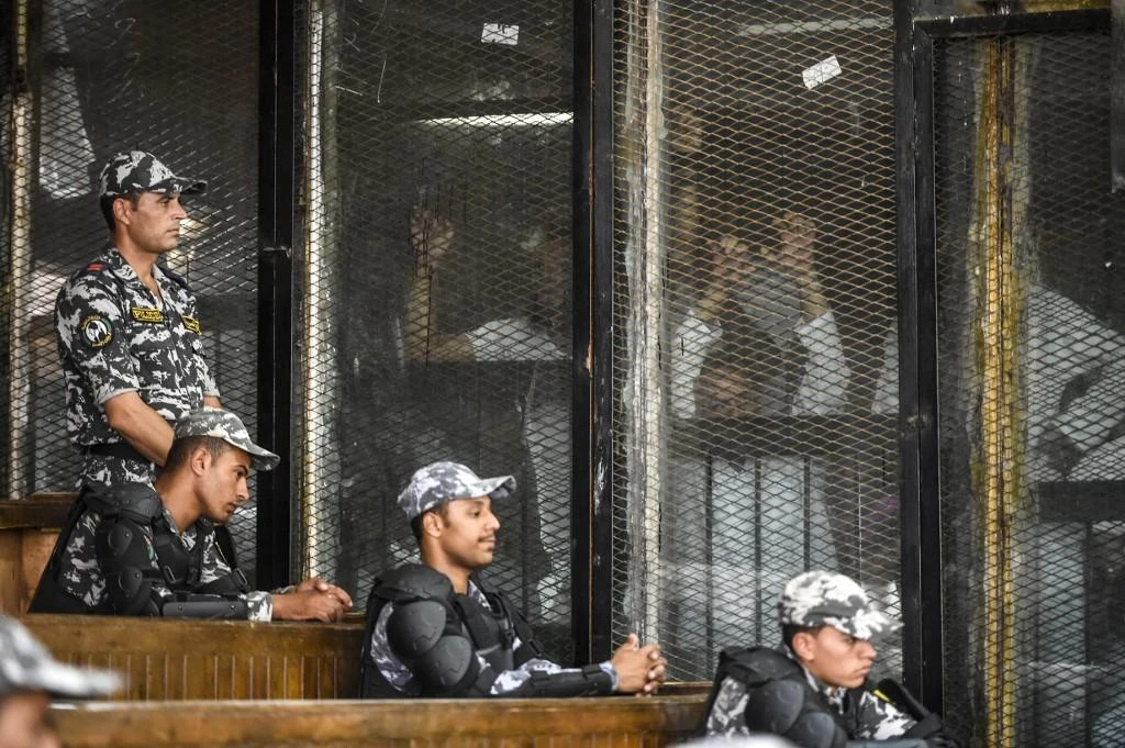 Above, Muslim Brotherhood members inside a glass dock during their trial in the capital Cairo on July 28, 2018. (AFP file)