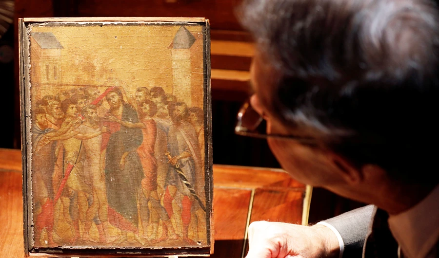 Art expert Eric Turquin inspects the painting "Christ Mocked", a long-lost masterpiece by Florentine Renaissance artist Cimabue in the late 13th century, which was found months ago hanging in an elderly woman's kitchen in the town of Compiegne, displayed in Paris, France, September 24, 2019. (REUTERS)
