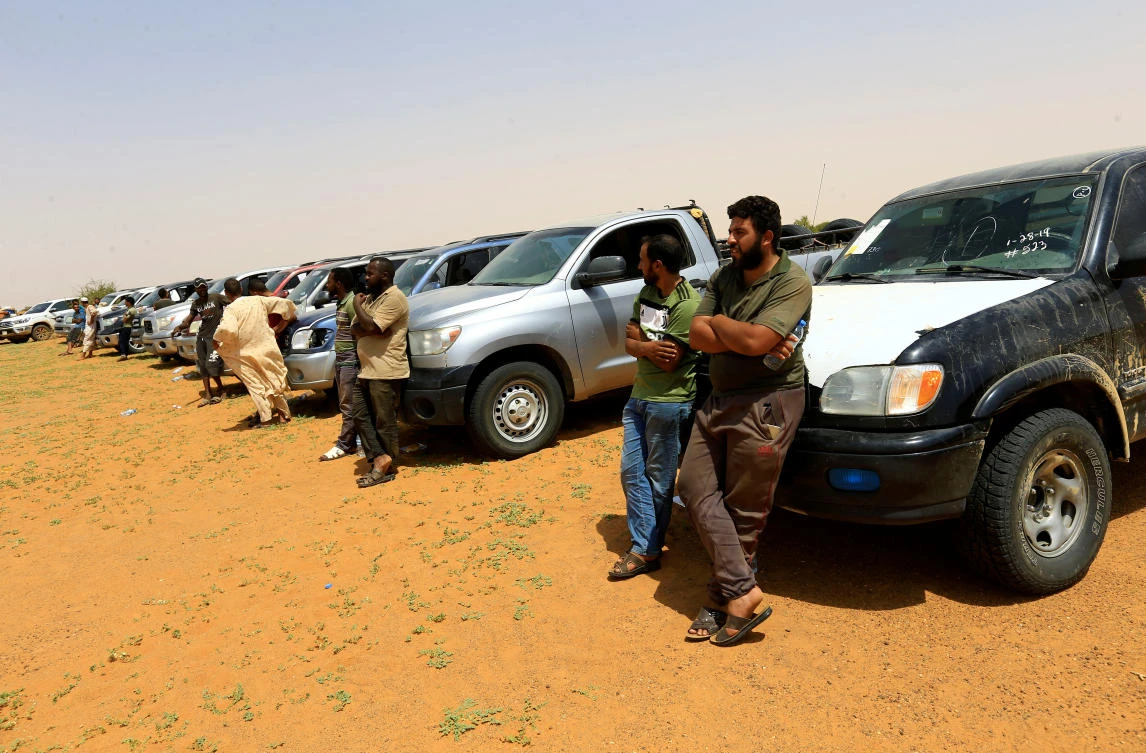 Libyan smugglers stand next to vehicles after being stopped by Sudan's paramilitary Rapid Support Forces (RSF) during an operation to locate and arrest Irregular migrants from Ethiopia, Sudan and Chad who were abandoned by traffickers in a remote desert area near the Libyan border and taken to the Khartoum State border, Sudan September 25, 2019. (Reuters)