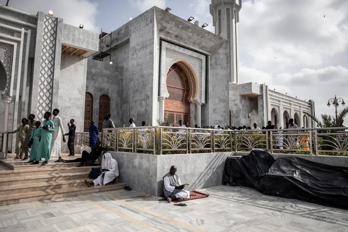 Worshippers are seen waiting outside the Great Mosque of the Mourides on September 27, 2019 in Dakar, ahead of its inauguration. (AFP)