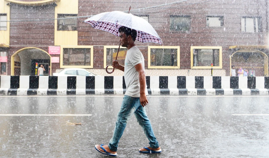 An Indian man shelters under an umbrella as he makes his way as heavy rain falls in Amritsar on September 27,2019. (AFP)