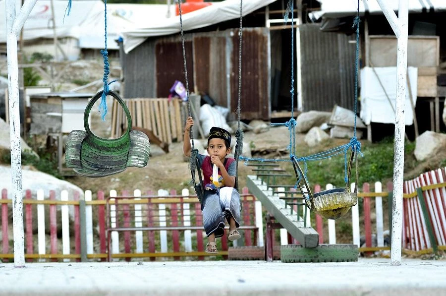 This picture taken on September 25, 2019 shows 9-year-old Rafi Adit Putra sitting on a swing near his living place. (File/AFP)