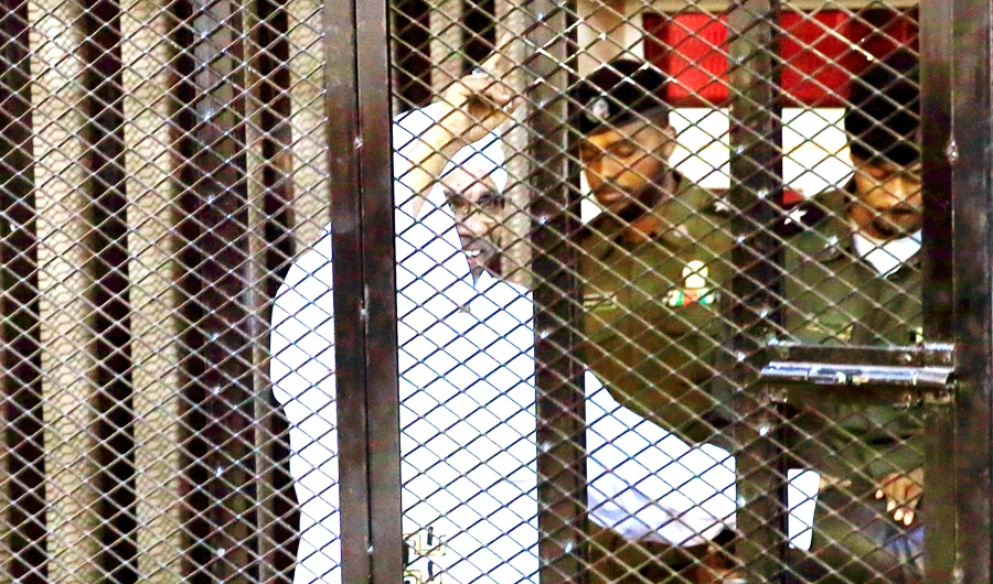 Sudan’s former President Omar Bashir sits inside a cage at the courthouse where he is facing corruption charges in Khartoum on Saturday. (Reuters)