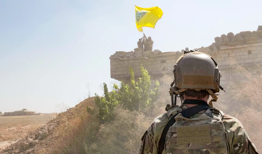 In this Sept. 21, 2019, photo released by the U.S. Army, a U.S. Soldier oversees members of the Syrian Democratic Forces as they demolish a Kurdish fighters' fortification and raise a Tal Abyad Military Council flag over the outpost as part of the so-called "safe zone" near the Turkish border. (AP)