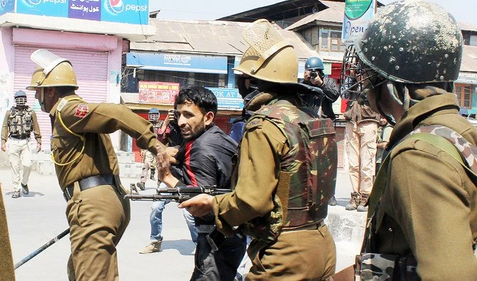 Indian policemen detain a Kashmiri citizen during clashes with the Indian police following gun fights between suspected militants and Indian forces in South Kashmir, in Srinagar on April 1, 2018. (AFP)