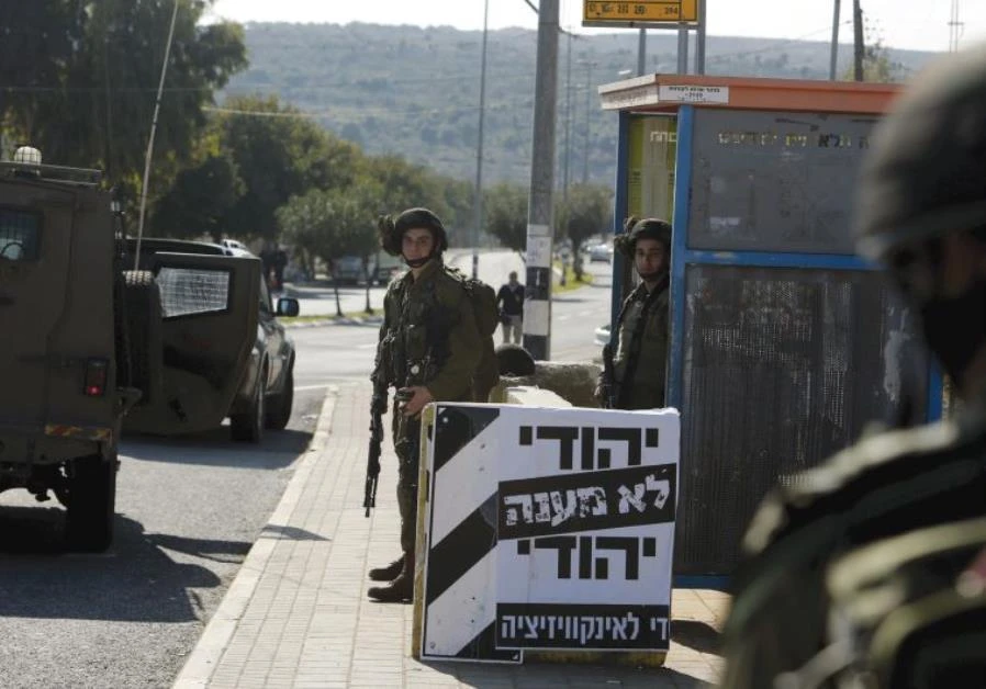 IDF Soldiers stand guard at the entrance to Ariel. (Reuters)