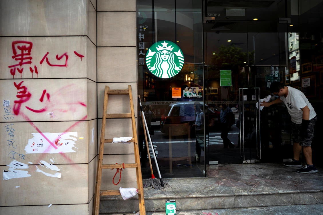 A worker cleans graffiti sprayed by anti-government protesters at a Starbucks coffee shop a day after a protest in Causeway Bay district, Hong Kong, China, September 30, 2019. (Reuters)