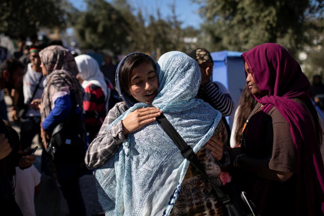 Migrants from the Moria camp embrace before boarding a bus to the port of Mytilene from where they will be transferred to the mainland, on the island of Lesbos, Greece, September 30, 2019. (Reuters)