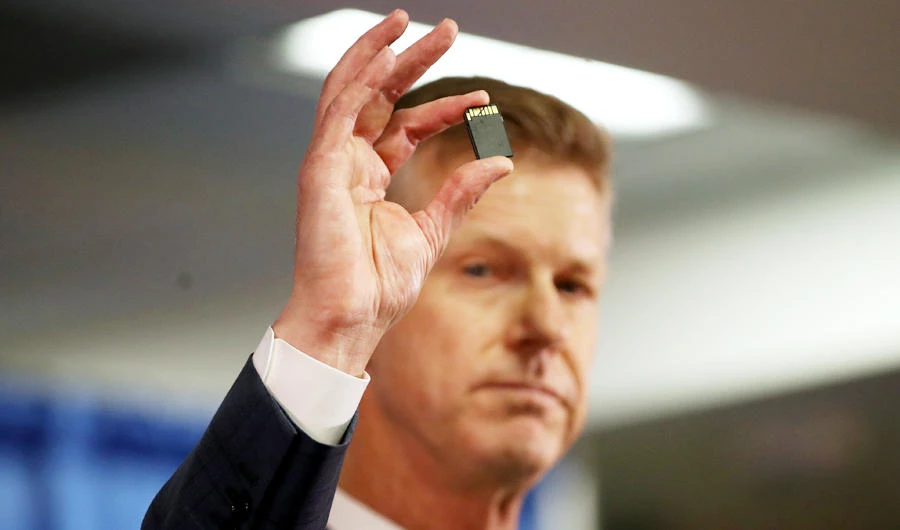 United States attorney David L. Anderson holds an SD memory card as he speaks during a news conference on September 30, 2019 in San Francisco, California. (AFP)