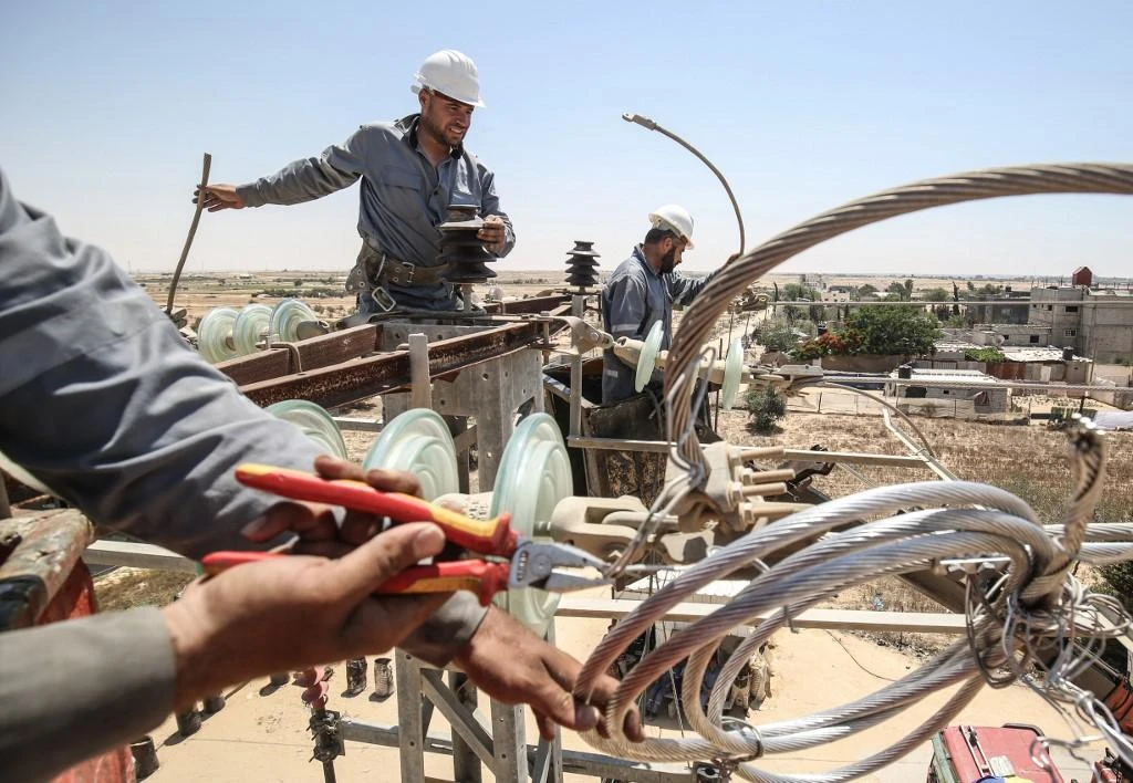 Palestinian electricity company workers inspect power installations in Rafah at the southern Gaza Strip in this June 25, 2019 file photo. (AFP)
