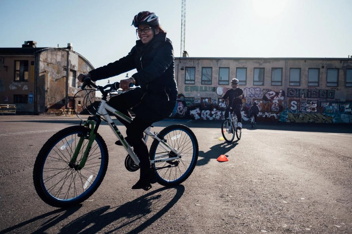 An immigrant woman rides a bike on September 20, 2019 on the gimcana track in Merihaka area, in Helsinki, Finland, as she takes part in the Let's Ride project offering free cycling lessons. (File/AFP)