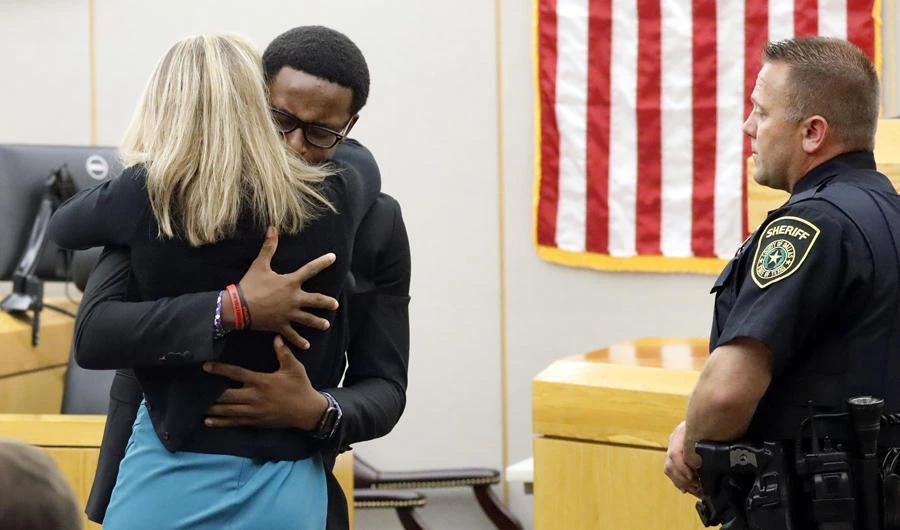 Botham Jean's younger brother Brandt Jean hugs convicted murderer and former Dallas Police Officer Amber Guyger after delivering his impact statement to her after she was sentenced to 10 years in jail ON Oct. 2, 2019, in Dallas. Guyger shot and killed Botham Jean, an unarmed 26-year-old neighbor in his own apartment last year. She told police she thought his apartment was her own and that he was an intruder. (Tom Fox/The Dallas Morning News via AP, Pool)