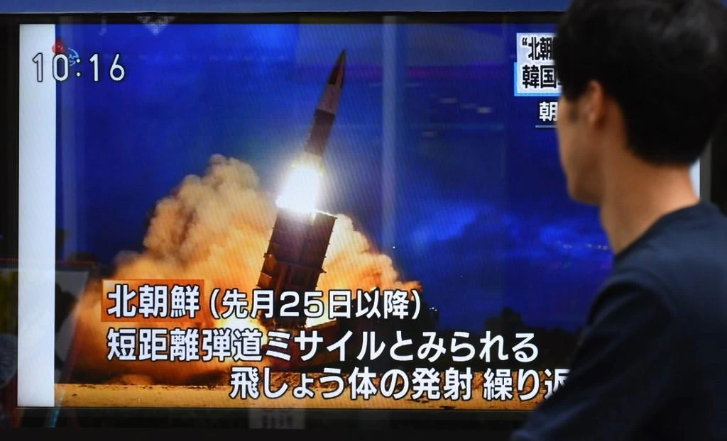 A Tokyo resident looks at a roadside television screen reporting on North Korea’s projectile launch on August 16, 2019. (AFP)