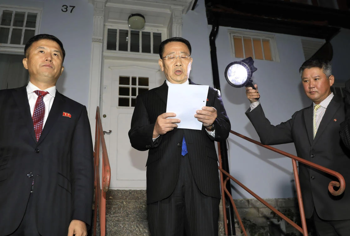 North Korean negotiator Kim Miyong Gil, center, reads statement outside the North Korean embassy in Stockholm on Saturday, Oct. 5, 2019. (Kyodo News via AP)