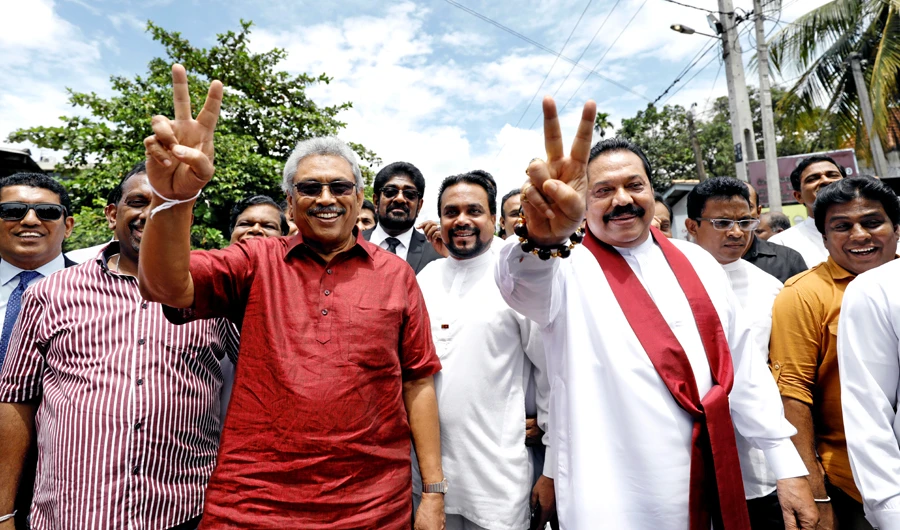 Sri Lanka People's Front party presidential election candidate and former wartime defense chief Gotabhaya Rajapaksa (L) and his brother, former president and opposition leader Mahinda Rajapaksa, show victory signs as they gesture at supporters after handing over nominations papers at the election commission ahead of Sri Lanka's presidential election, in Colombo, Sri Lanka October 7, 2019. (Reuters)