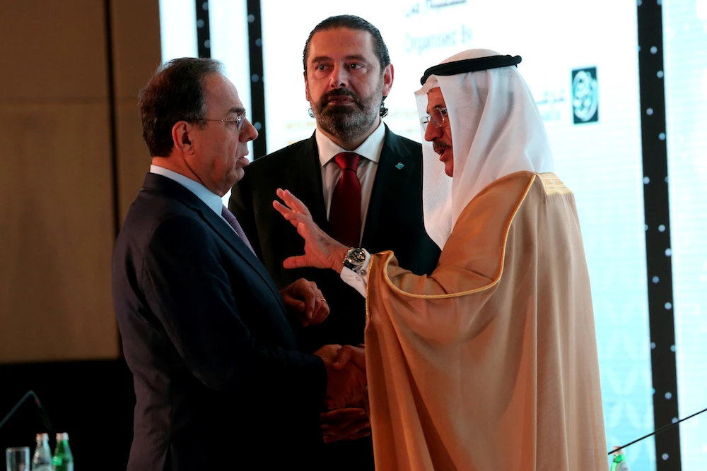 Lebanese Prime Minister Saad Hariri is seen as his advisor Nadim Al Mulla speaks with Sultan Bin Saeed Al Mansoori, United Arab Emirate's economy minister, Oct. 7, 2019. (File/Reuters)