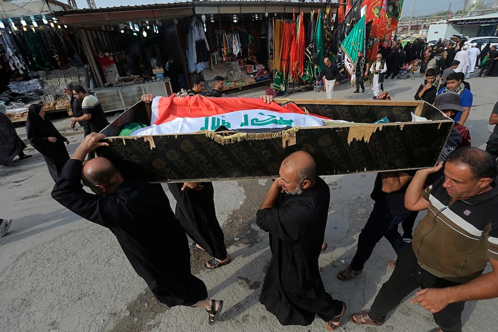 Mourners carry the flag-draped coffin of Hassan Radi, a protester killed during anti-government demonstrations, during his funeral in Najaf, Iraq, Tuesday. (AP)