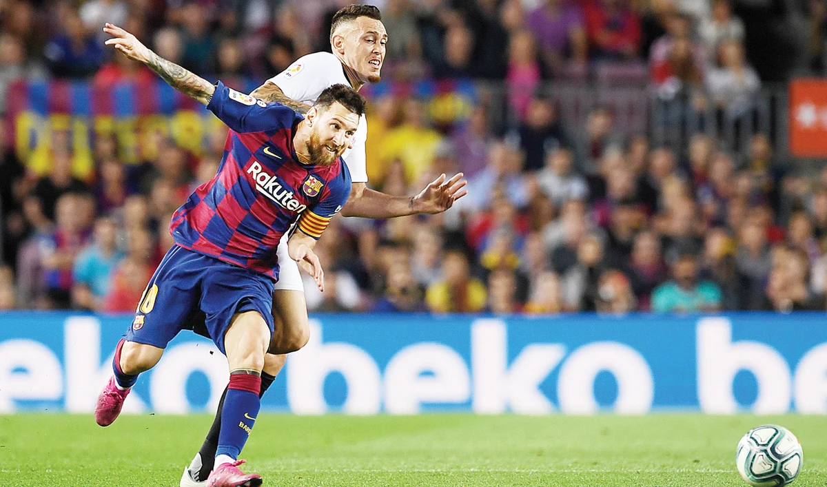 Barcelona's Argentine forward Lionel Messi against Sevilla's Brazilian midfielder Fernando during their Spanish league football match Sunday. (AFP)