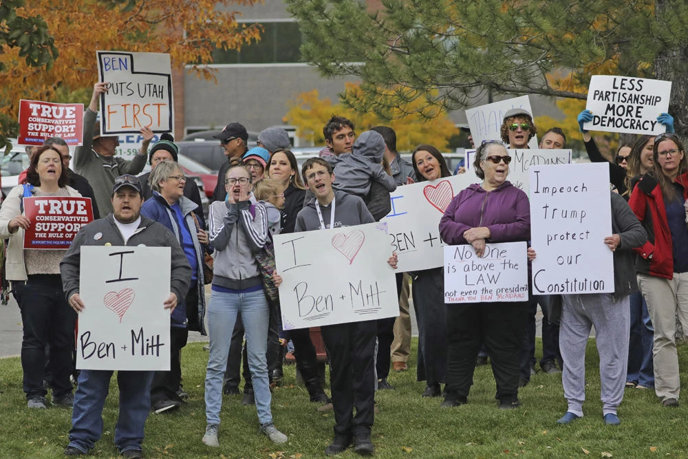 Supporters of the impeachment inquiry rally near the office Democratic US Rep. Ben McAdams on Oct. 9, 2019, in West Jordan, Utah. Trump on Thursday stirred up a storm on social media ahead of his visit to Minneapolis, Minnesotta. (AP Photo/Rick Bowmer)