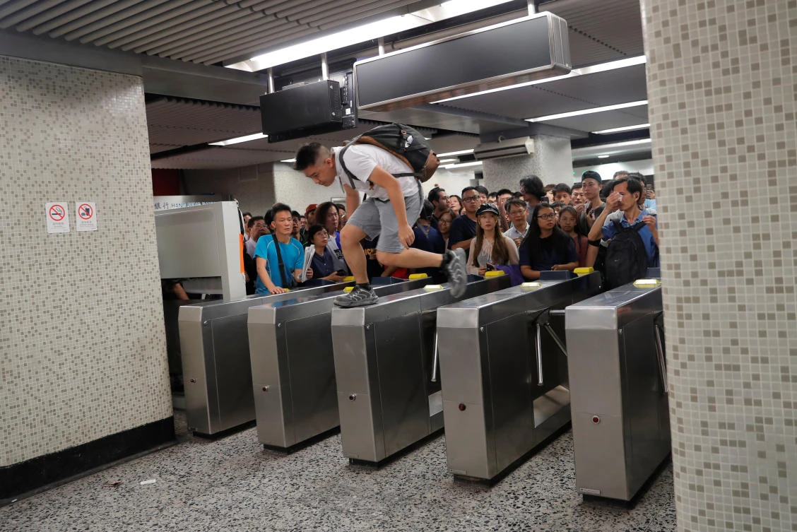 A commuter jumps over a turnstile at Yau Ma Tei station of Hong Kong’s metro system after its partial opening. The usually efficient service was forced to shut down after arson attacks by anti-government protesters. (Reuters)