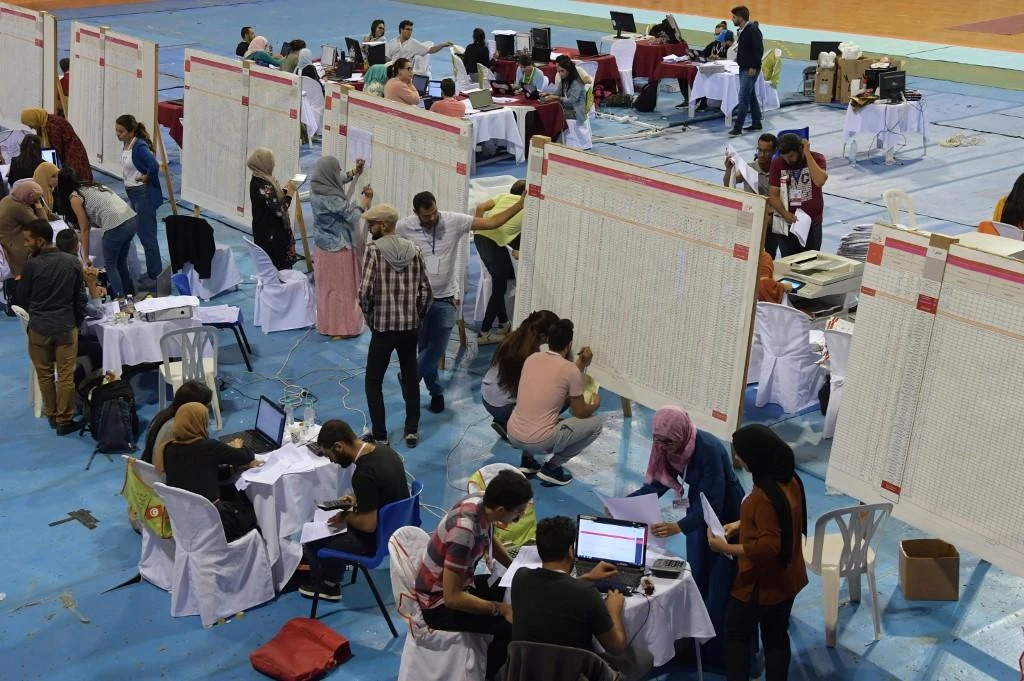 Staff members of Tunisia’s Independent Higher Authority for Elections (ISIE) sort through result lists of the legislatifs vote at a sorting station in the capital Tunis on October 7, 2019.