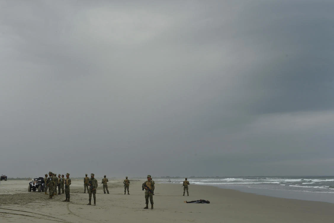 Security forces form a cordon around the lifeless body of Emmanuel Cheo Ngu, of Cameroon, on the shore of Boca Barra Beach, in Puerto Arista, Mexico, Friday, Oct. 11, 2019. (AP)
