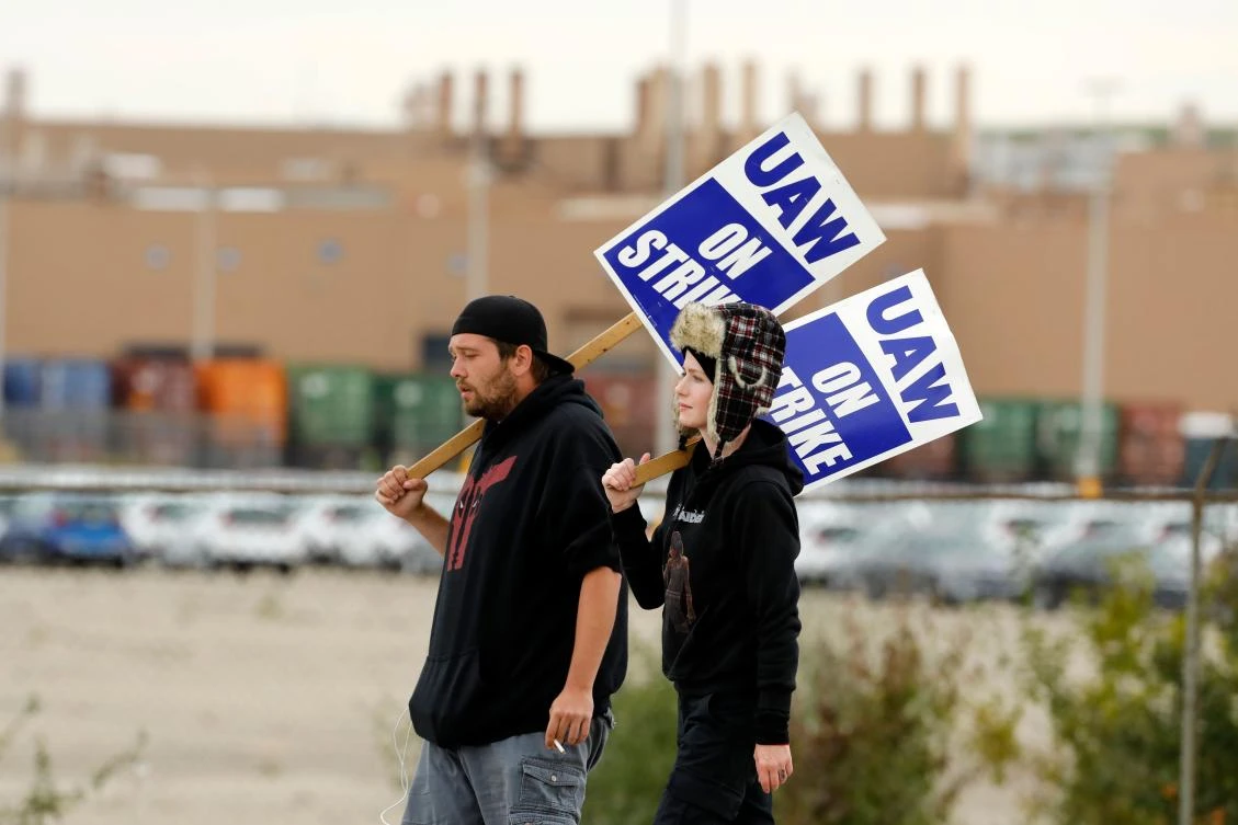 Amy (R) and Matthew Harper (L) walk the picket line outside General Motors (GM) Orion Assembly on October 11, 2019 in Orion Township, Michigan. (File, AFP)